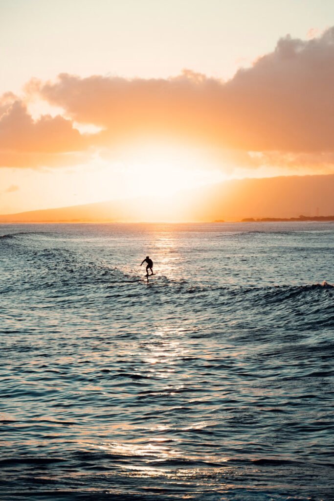 Surfer riding a wave at sunset off Gili Trawangan